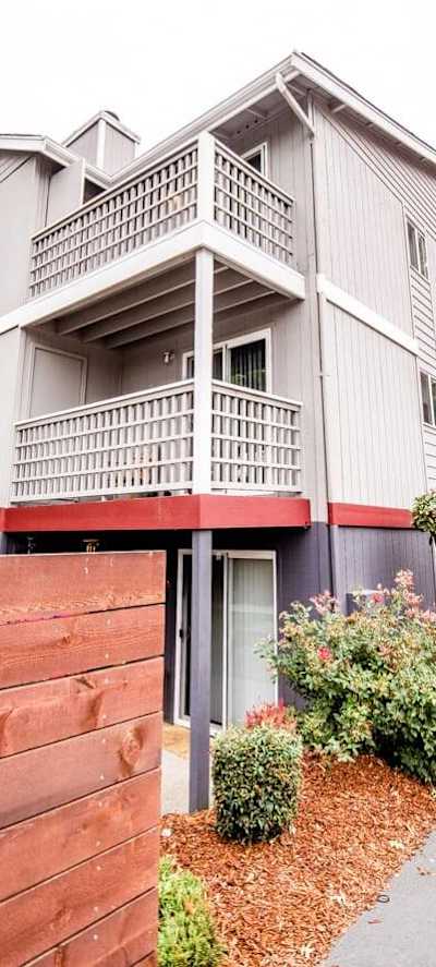 A grey building with a red fence in front.