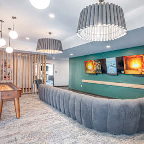 A room with a grey couch and a wooden table.