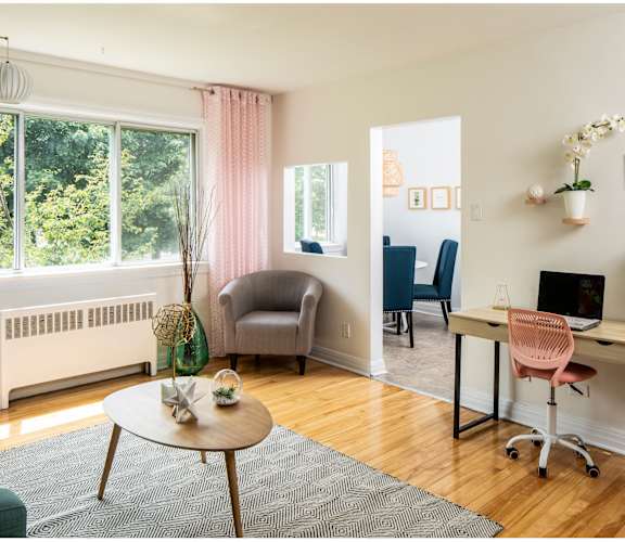 A room with a desk, chair, and window.