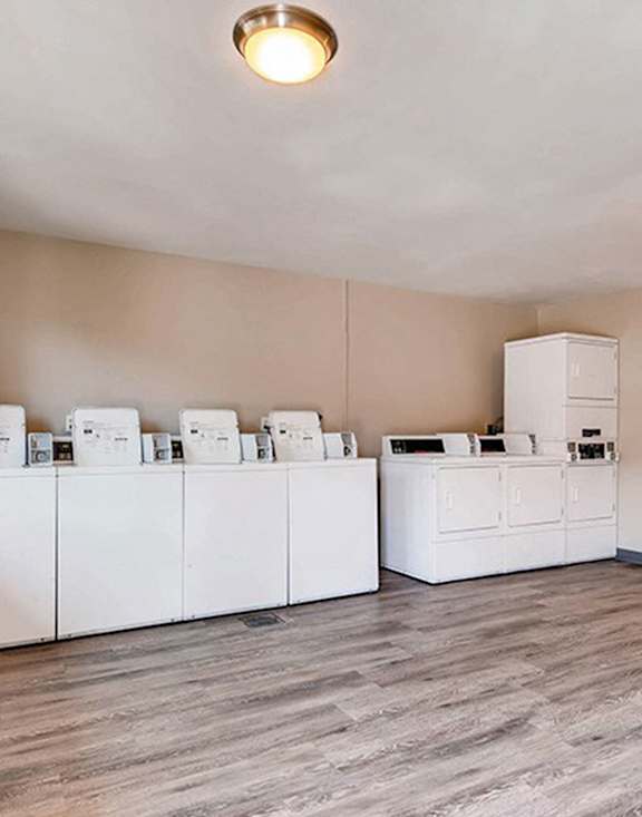 A laundry room with 4 washers and dryers.