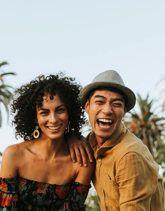 Stock Photo of Friends Smiling by Palm Trees-MEDAM.