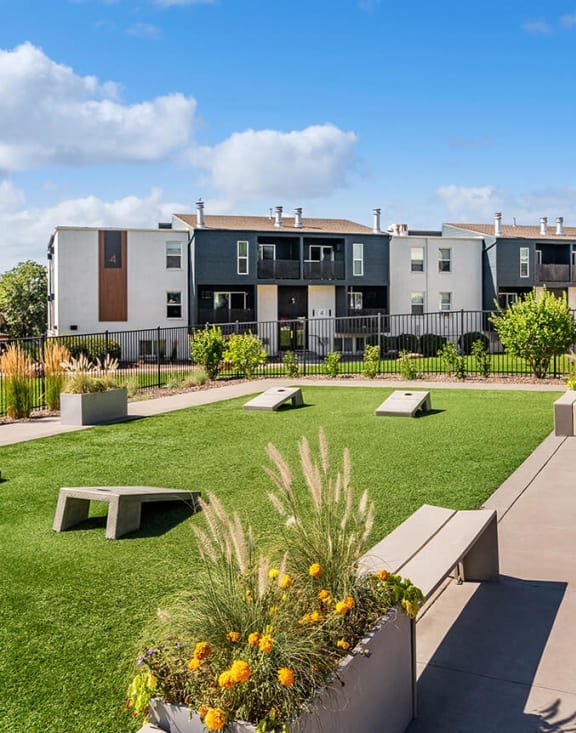 Apartment exterior and cornhole courts at Waterfront Apartments in Lakewood, Colorado