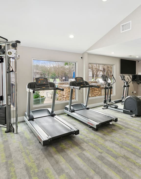 Community Fitness Center with Equipment at Woodcreek Apartments located in Arlington, TX-MEDAM.