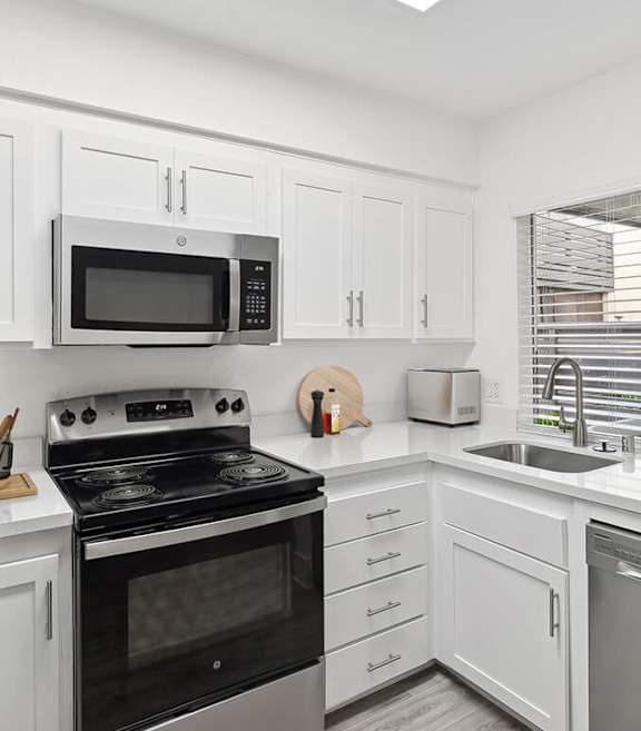 Model Kitchen with White Cabinets and Wood-Style Flooring at Horizon Apartments located in Santa Ana, CA-SMLAM.