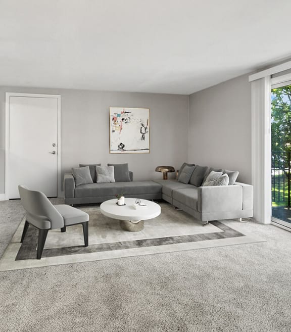 Model Living Room with Carpet and Patio Accessibility at Village at Marshfield Apartments located in Marshfield, MA-SMLAM.
