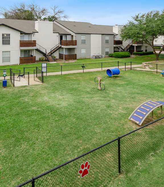 Community Dog Park with Agility Equipment at Autumnwood Apartments located in Arlington, Texas.