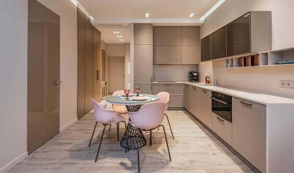 A modern kitchen with a dining table set for two.