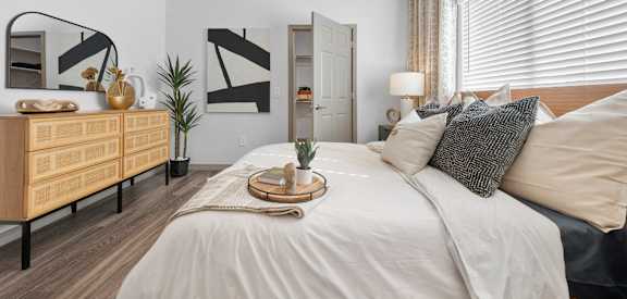 A bedroom with a bed, dresser, and mirror.