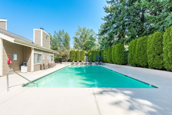 Townhomes with a View Pool Area with Hedges and Building Exterior