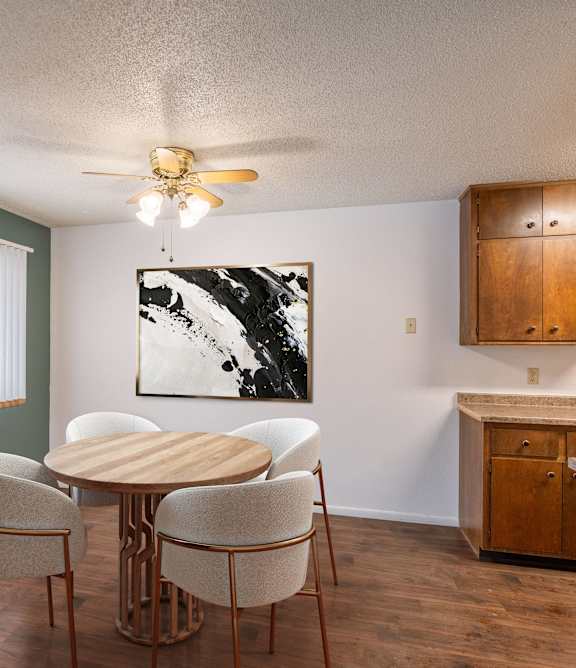 a dining room with a table and chairs and a ceiling fan