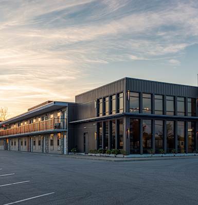 A modern building with a parking lot in front.