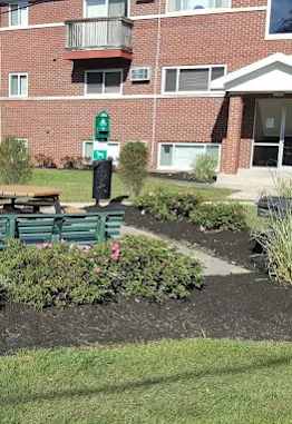 A small garden in front of a red brick building.