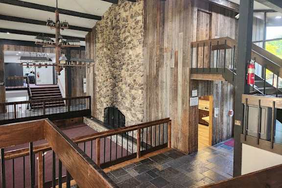large room with a staircase and a stone wall