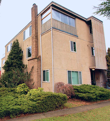 A beige building with a green door and windows.