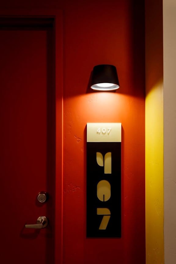 A red door with a black handle and a sign that says 497 2007.