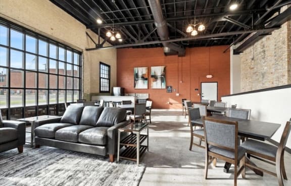 Brooke Street Lofts large community room with massive windows, seating, and a kitchenette