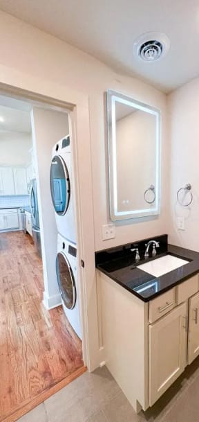 a small bathroom with a sink and a washer and dryer