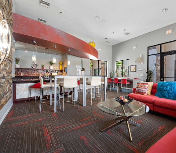 A living room with a red couch and a glass coffee table.