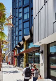 people sitting on benches in front of a tall building