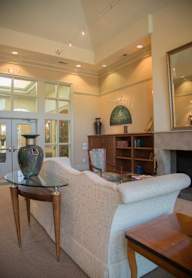 A living room with a white couch and a glass coffee table.
