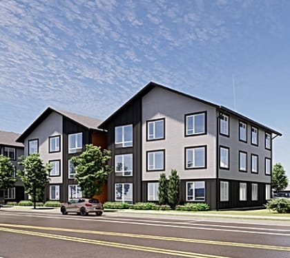 A modern apartment building with a car parked in front.