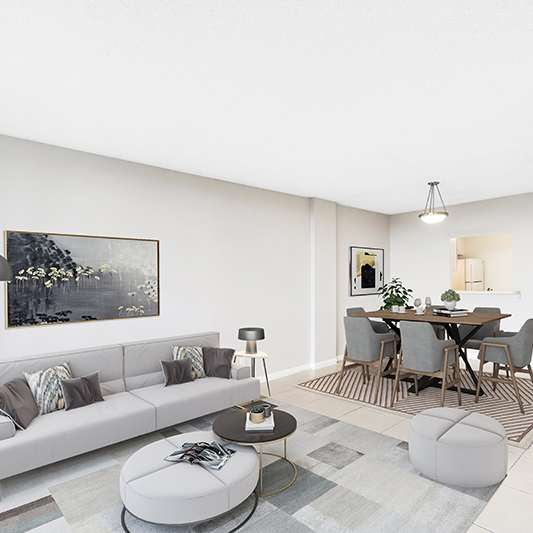 A modern living room with a grey sofa, a coffee table, and a dining table set up.