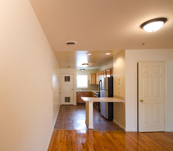 view of kitchen from the living; stainless steel appliances, tiled floors and wooden cabinets