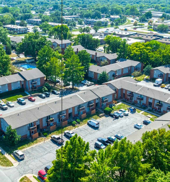 A bird's eye view of a parking lot surrounded by apartment buildings.