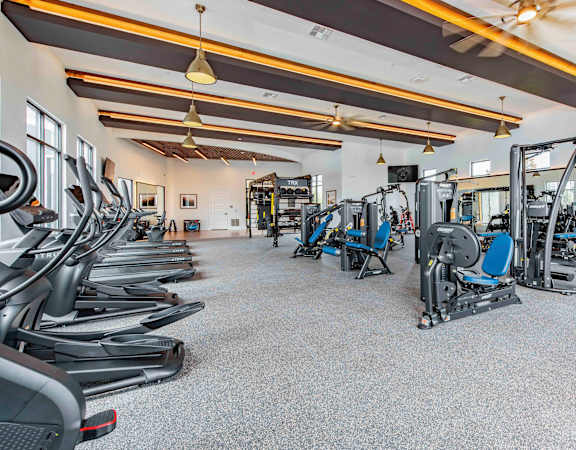 A spacious gym with a variety of cardio and strength training equipment.