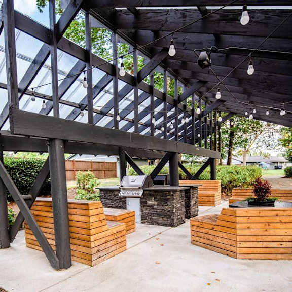 A wooden deck with a glass roof and a concrete floor.