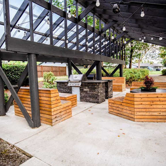 A wooden deck with a glass roof and a concrete floor.