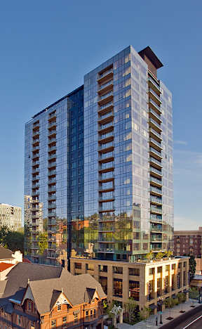 A modern glass building stands tall in a cityscape.