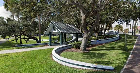 A small pavilion is surrounded by a grassy area and trees. at The Teale New Haven Apartments, Melbourne, FL, 32904
