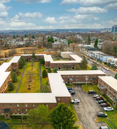A large building complex with a parking lot in front.