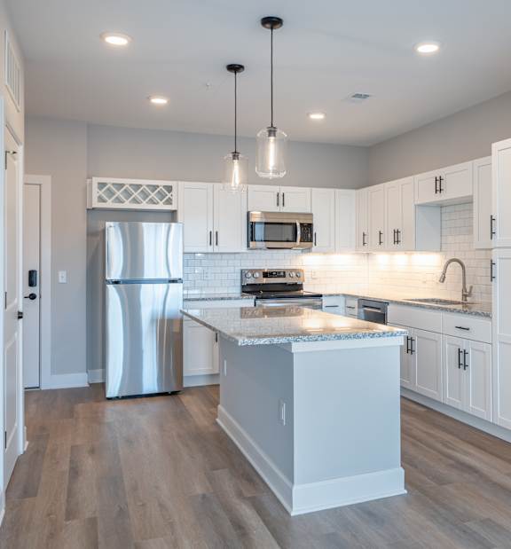 A modern kitchen with white cabinets and a central island.
