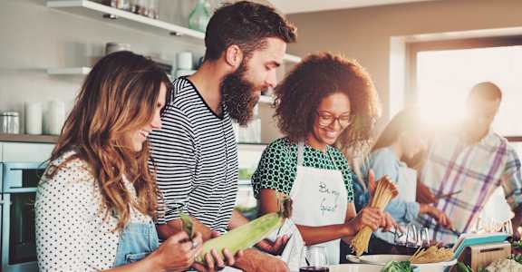 a group of people in a kitchen preparing food