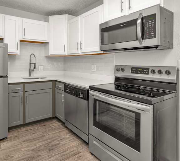 A kitchen with black cabinets and a white countertop.