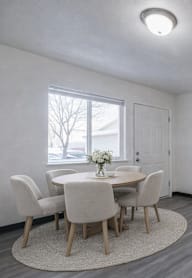 A living room with a couch, chairs, and a table.