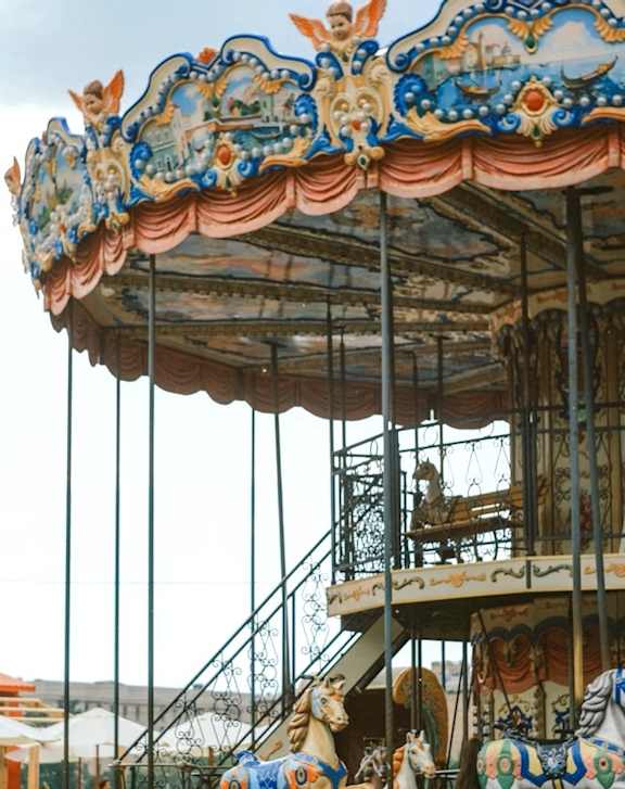 A carousel with horses and a canopy with a dragon on it.