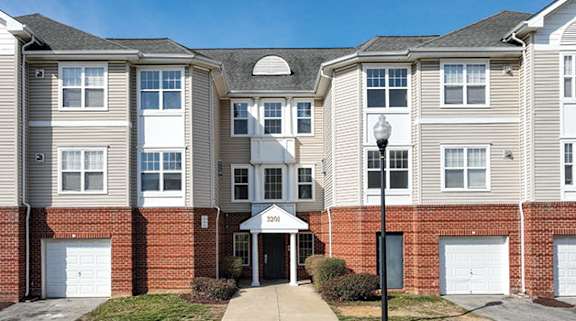 an apartment building with a sidewalk in front of it at Overland Gardens, Landover, MD