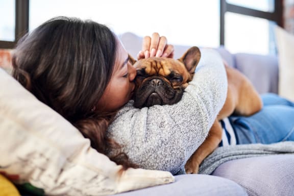a woman laying on a couch with her dog