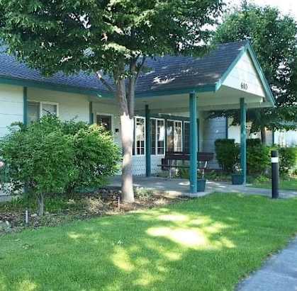 a house with a porch and a tree in front of it