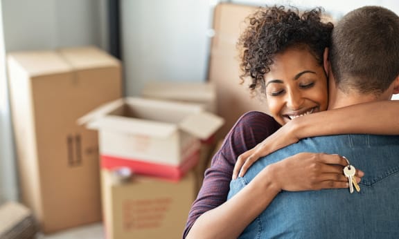 a couple hugging in a room full of boxes