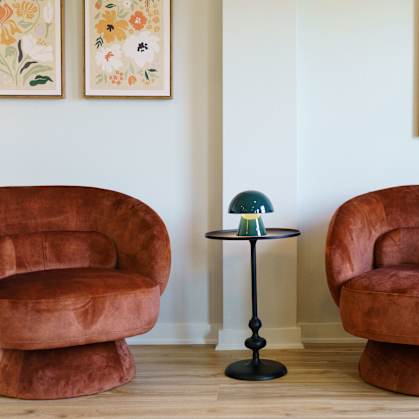 Two brown chairs and a table in a room.