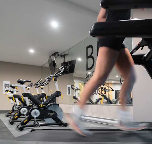 a gym with treadmills and other exercise equipment in a room with a window