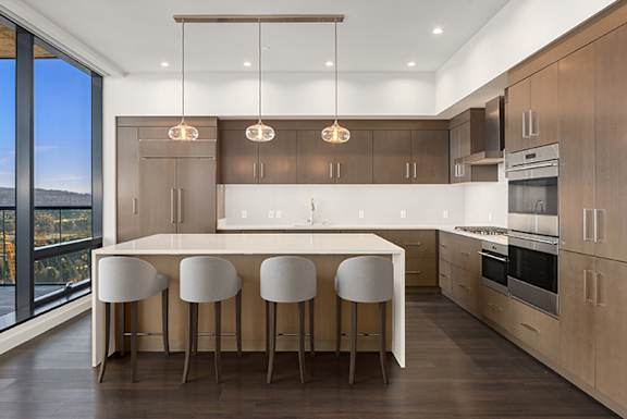 a modern kitchen with a white island and white chairs at Two Lincoln Tower Apartments, Bellevue, WA, 98004