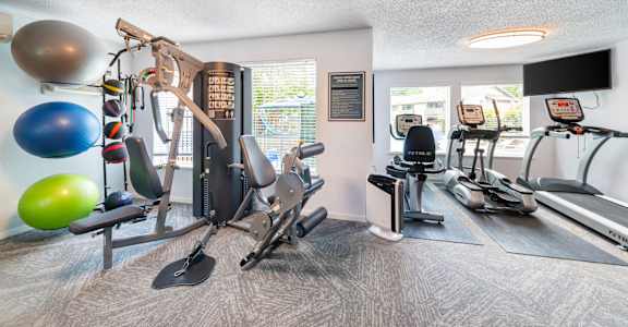 A well equipped gym with a variety of exercise equipment.