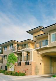 A large, modern apartment building with a covered walkway connecting the buildings.