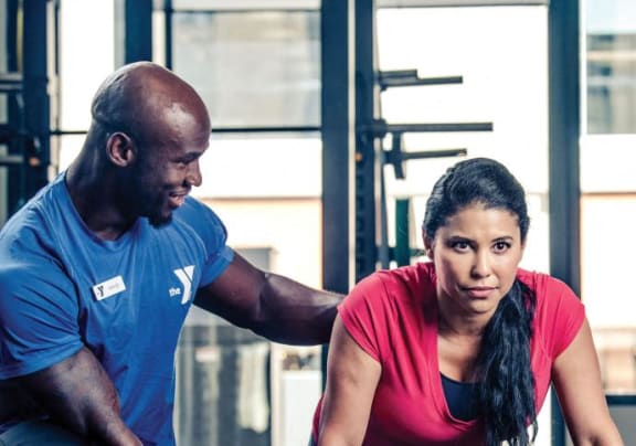 a man and woman looking at a balance board in a gym