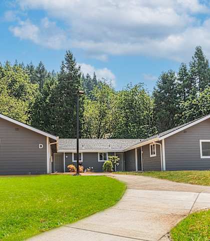 a gray house with a sidewalk in front of it